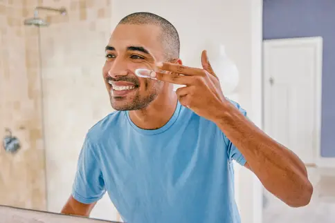 un hombre aplicándose loción en la cara