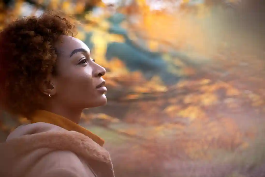 photo of thoughtful, young woman in autumn park