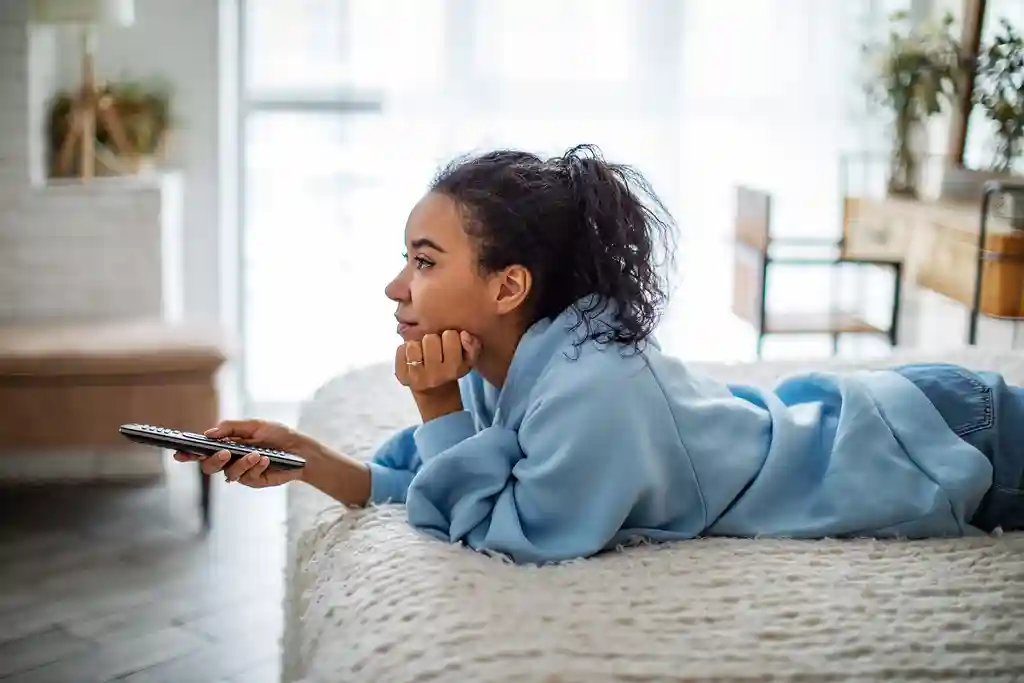 photo of young woman watching tv