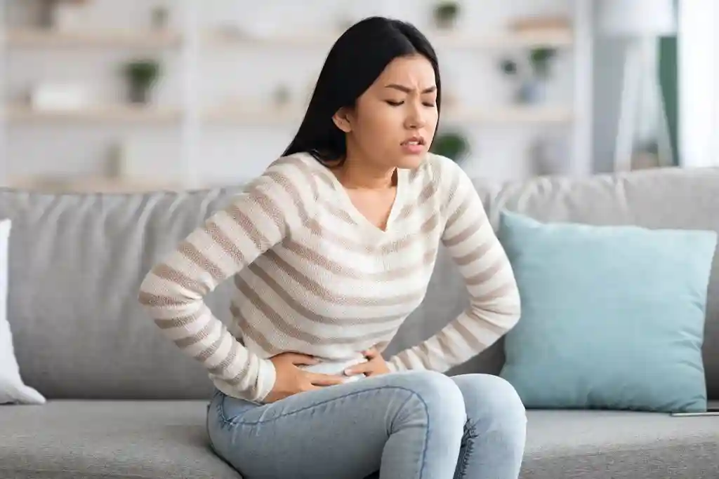 photo of woman holding stomach in pain from cramps