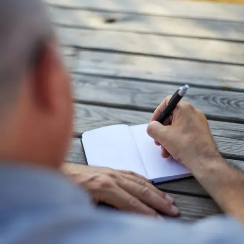 photo of man writing in journal